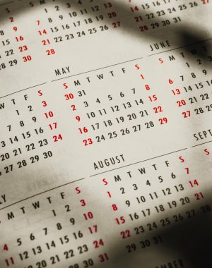 Close-up of a 2023 calendar page capturing sunlight and shadows, highlighting the months of May, June, and August.